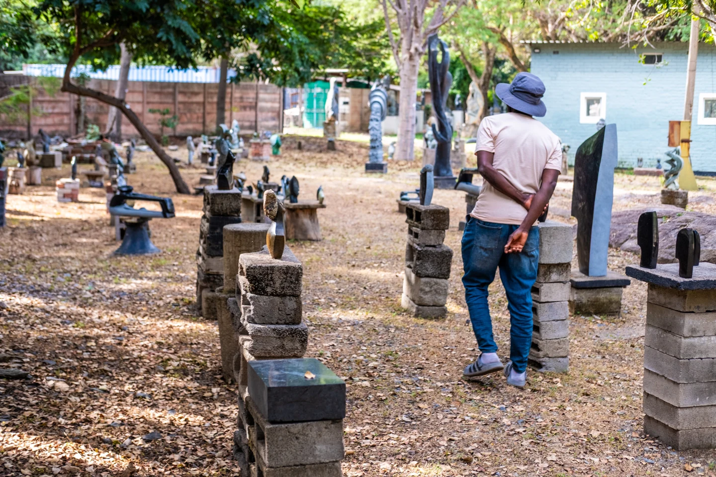 A visitor walking among stone sculptures in an outdoor garden