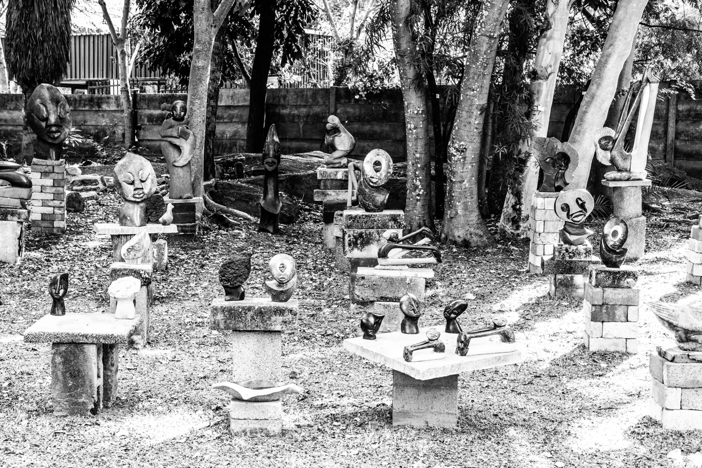Black-and-white photograph of sculptures displayed among trees