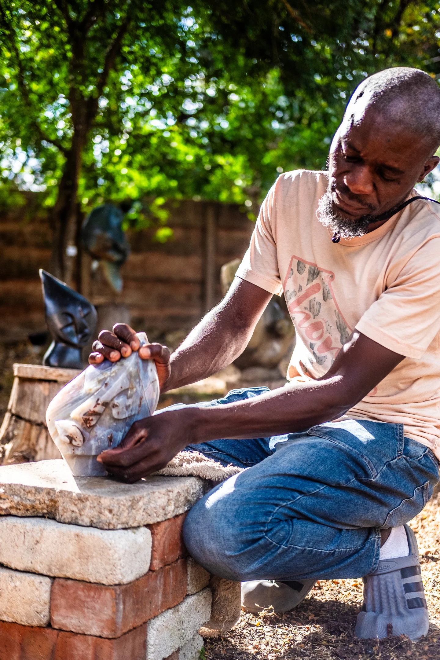 A sculptor examining a polished pale blue form